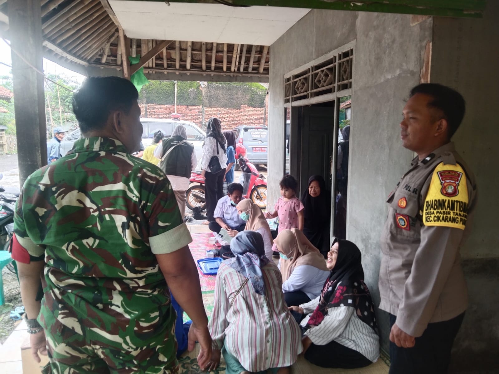 Polsek Cikarang Pusat Dampingi Layanan Pengobatan Gratis Puskesmas Sukamahi Pasca Banjir di Desa Pasirtanjung